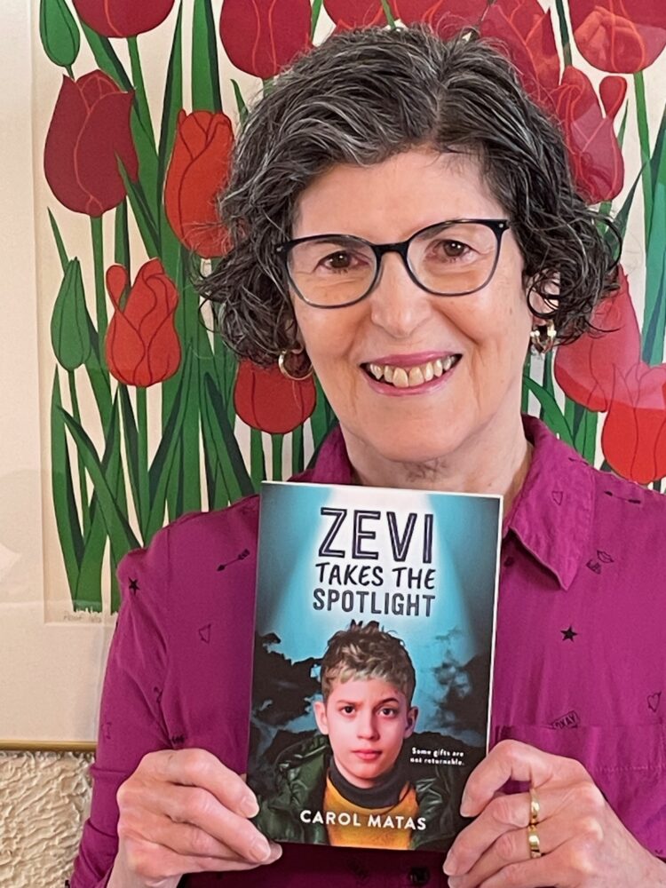 Author Carol Matas holds her new book, Zevi Takes the Spotlight